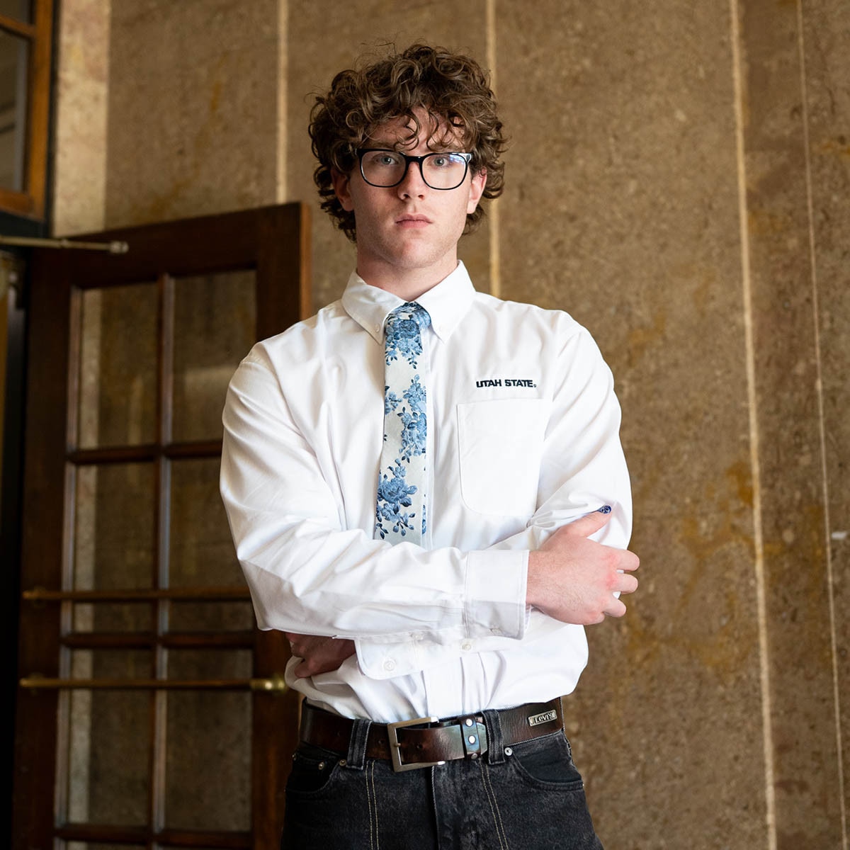 Man wearing utah state oxford white long-sleeve button up dress shirt with cream and blue floral boon tie